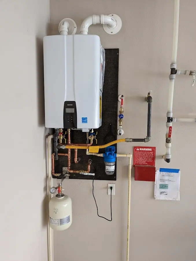 Professional plumber installing copper piping in a Monroe home